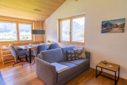 Essbereich der Ferienwohnung BergZeit in Schoppernau mit großem Tisch bequemen Stühlen und Panoramablick auf die Berge