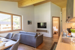 Wohnbereich der Ferienwohnung BergZeit in Schoppernau mit Chillcouch riesigem QLED TV mit SAT und Amazon Prime Video
